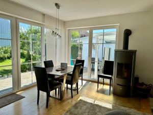 a dining room with a table and chairs and a fireplace at Escape by Landhaus Lindenberg in Buchloe