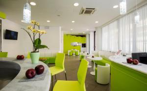 ein Wohnzimmer mit grünen Stühlen und einem Tisch in der Unterkunft Hotel Scarlet in Rimini