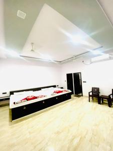 マトゥラーにあるRudra Guest Houseの広い白い客室で、ベッド2台が備わります。