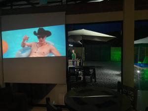 a large screen with a man in a cowboy hat on it at Cabaña El Anhelo Tradición in Ginebra