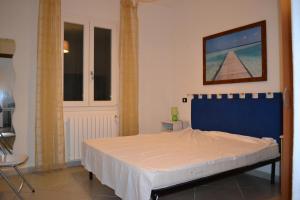 a bedroom with a bed and a picture on the wall at Casetta Azzurra in Pomonte