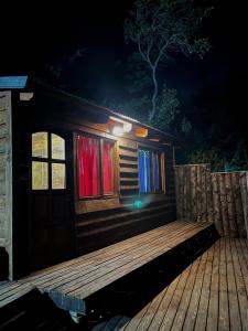 a cabin with a wooden deck at night at Cabaña de montaña Amber in San Carlos de Bariloche +7 photos