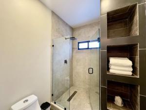 a bathroom with a shower with a glass door at Casa Alva Suite in Valle de Guadalupe 3 BR 3 BA in Los Niños