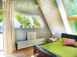 a bedroom with a green bed and a window at Villa Sandäng in Löderup