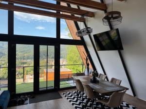 a dining room with a table and a large window at Ambiance Aframe in Câmpulung Moldovenesc