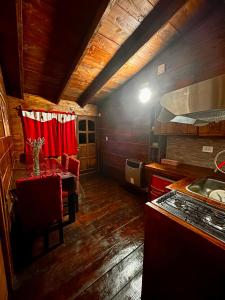a kitchen with a table and a red curtain at Cabaña de montaña Amber in San Carlos de Bariloche