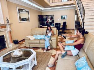 two women sitting on couches in a living room at Ocean House in Ferrel