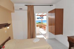 a bedroom with a bed and a view of the ocean at Irene Studios in Kefalos