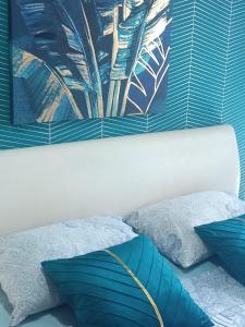 a bedroom with blue pillows and a painting on the wall at Ema Lux Apartments in Soko Banja