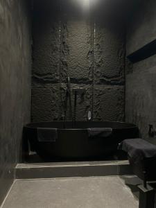 a black bathroom with a bath tub and a sink at Iunn Apartment 5 in Vlorë +20 photos