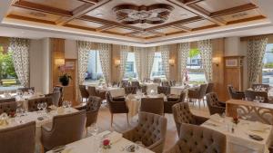 ein Restaurant mit weißen Tischen und Stühlen und Fenstern in der Unterkunft Hotel Alte Post Bonaduz in Bonaduz