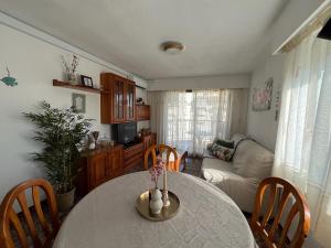 ein Wohnzimmer mit Tisch und Stühlen in der Unterkunft Apartamento Acogedor con Piscina, Cerca de la Playa in Playa de Gandia