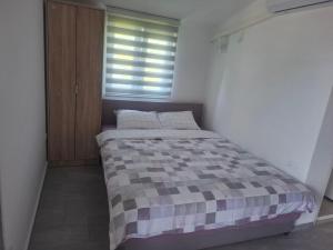 a bedroom with a bed with a checkered blanket at Apartman Andjela 1 in Budva