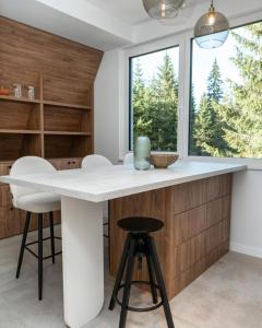 een keuken met een wit aanrecht en krukken bij Engadin's Family Apartment in Jahorina