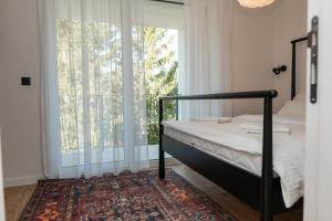 een slaapkamer met een bed en een groot raam bij Engadin's Family Apartment in Jahorina