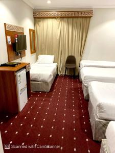 a hotel room with two beds and a television at فندق مواسم الخير الدولية in Az Zahrāʼ