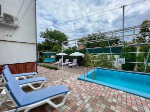 a patio with two chairs and a swimming pool at Guest house VadLen in Odesa