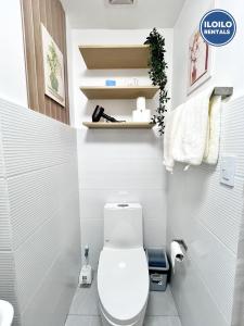a small bathroom with a white toilet and shelves at Modern Studio Comfort at Bernwood Tower in Iloilo City