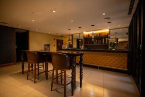 a bar in a restaurant with chairs and a kitchen at Elite Pod at Knightsbridge Residences Makati in Manila