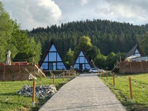 a walkway leading to a building with trees in the background at Ambiance Aframe in Câmpulung Moldovenesc