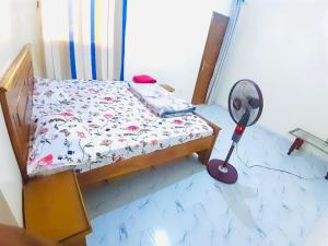 a small bedroom with a bed with a fan at 2chambres salon villa Thierno sene in Niakoul Rap