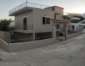 una casa con una valla delante en Alexandros Home, en Perdika