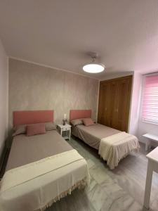 a bedroom with two beds and a window and a lamp at APARTAMENTO LUXURY Golf Center in Roquetas de Mar +18 photos