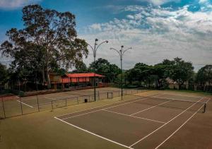 a tennis court with trees and a pavilion at Chalé Gratidão - Camping Carrion - ITU in Itu