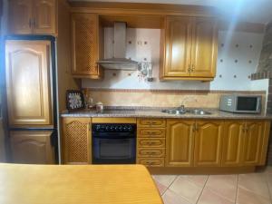 a kitchen with wooden cabinets and a sink at Casa Rural Las Eras I  +4 photos