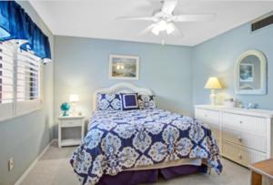 a blue bedroom with a bed and a ceiling fan at Hutchinson Island Resort-style Beachside Condo in Fort Pierce +23 photos