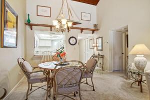 a dining room with a table and chairs and a clock at Hutchinson Island Resort-style Beachside Condo in Fort Pierce