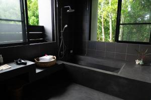 a black bathroom with a tub and a shower at 陽月-Hizuki- in Nakijin