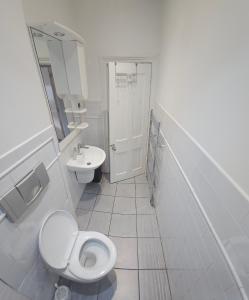 a white bathroom with a toilet and a sink at Bright & Modern Double Rooms in Central East London in London
