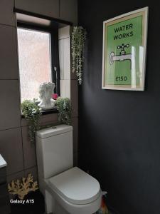 a bathroom with a toilet and a sign on the wall at 2 bedroomed homely house in Manchester +15 photos