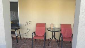 a table with three chairs and a table with a laptop at M&M Apartman in Tiszafüred