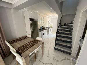 a kitchen with a staircase and a table and a refrigerator at Ege Naz Villa in Avşa Adası