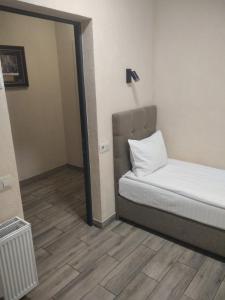 een kleine kamer met een bed en een spiegel bij Coffee Room in Odessa