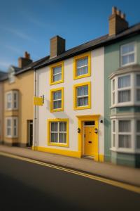 a building with a yellow door on a street at Ty Sunnymead Guesthouse in Aberystwyth