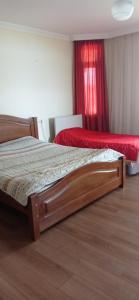 - une chambre avec 2 lits et un rideau rouge dans l'établissement Nino's Guesthouse, à Batoumi