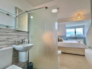 a bathroom with a sink and a bed at Penmorfa -4 Bed-3 Bath-Coastal Retreat Sleeps 9 in Trearddur +34 photos