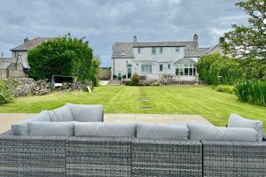 a large couch sitting in front of a house at Penmorfa -4 Bed-3 Bath-Coastal Retreat Sleeps 9 in Trearddur