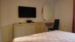 a bedroom with a bed and a television on the wall at Jelena Lapčići Budva in Budva