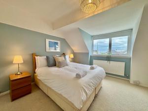 a bedroom with a large bed and a window at Penmorfa -4 Bed-3 Bath-Coastal Retreat Sleeps 9 in Trearddur