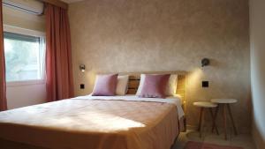 a bedroom with a bed with pink pillows and a window at Jelena Lapčići Budva in Budva
