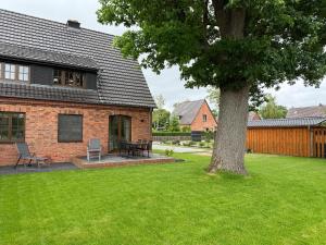 a brick house with a tree in the yard at Ferienhaus Lake Residence Müritz in Rechlin