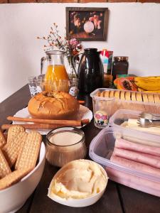 a table with bread and other food items on it at Camping Caldeirão Furado in São Thomé das Letras