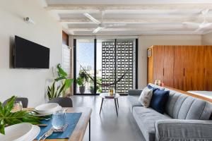 a living room with a couch and a table at Hola Donceles Suites in Cancún
