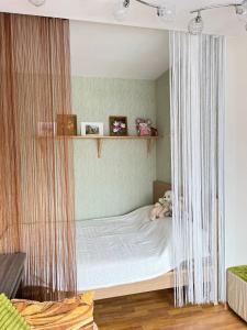 a childs bedroom with a bed with a curtain at Cosy flat near the Sea in Ventspils