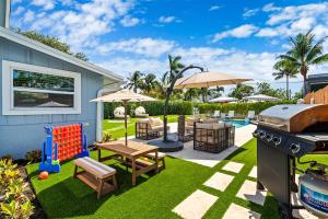 a backyard with a table and a grill and a playground at Walk to Atlantic Ave Pool Recently Renovated in Delray Beach