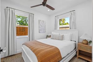 a white bedroom with a bed and two windows at Walk to Atlantic Ave Pool Recently Renovated in Delray Beach +15 photos
